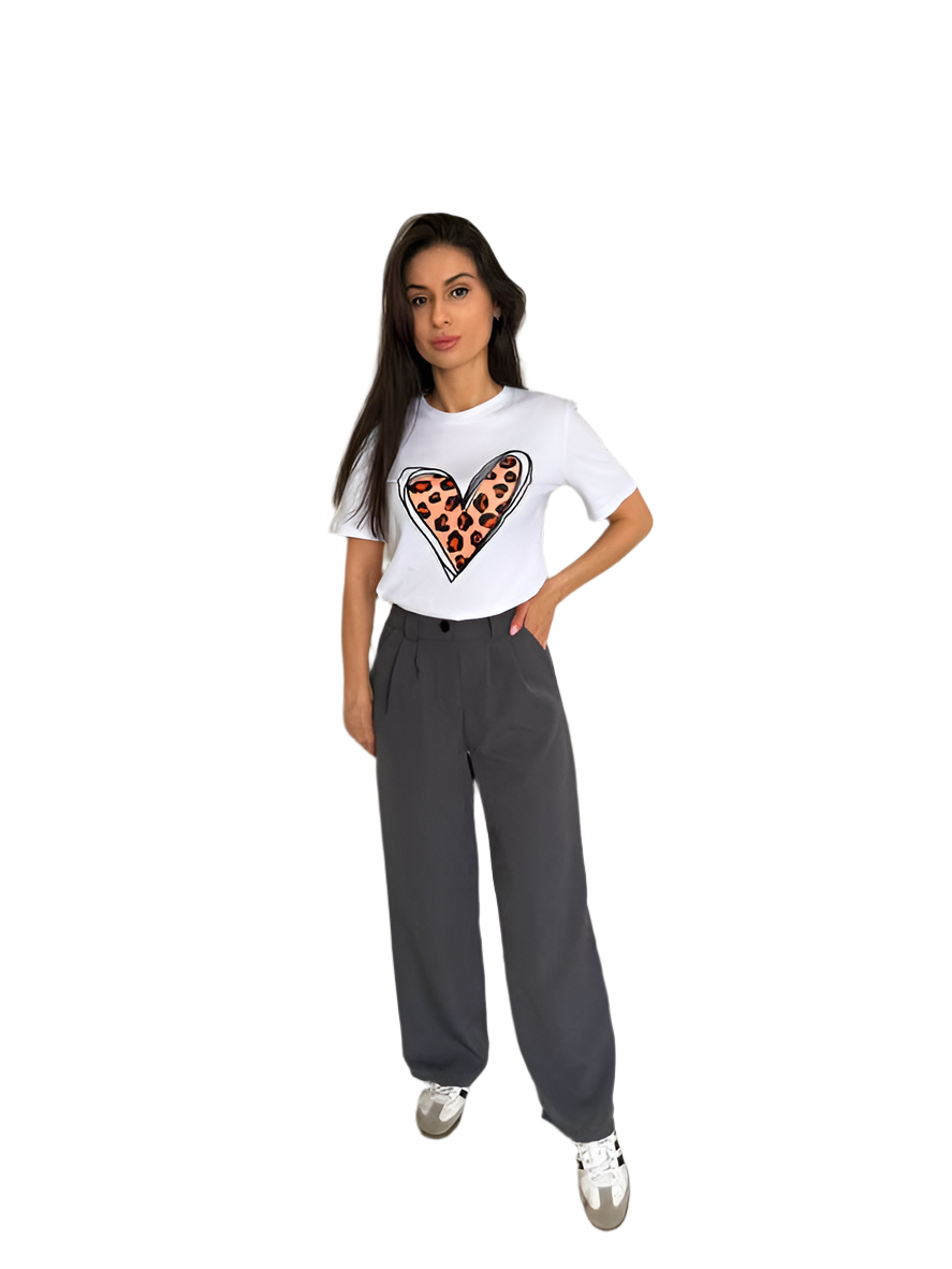 Woman wearing a white t-shirt with a heart design and gray pants on a white background
