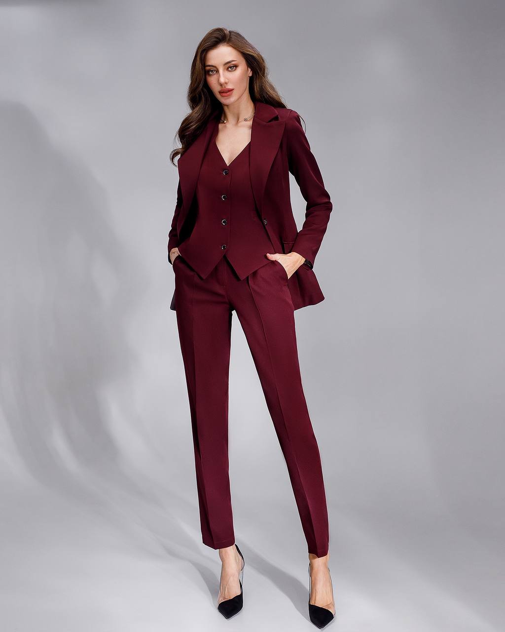 Woman wearing a burgundy suit on a gray background