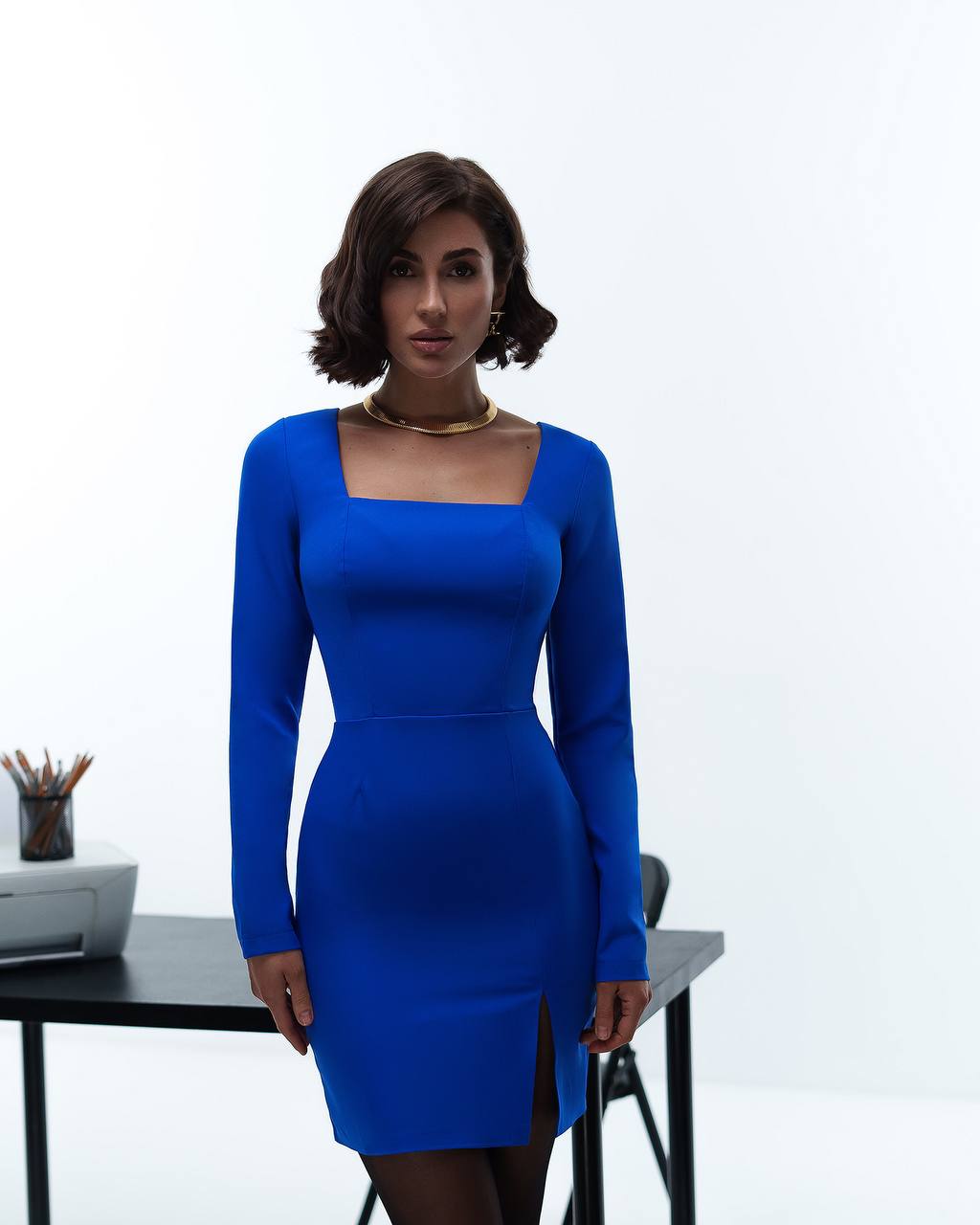 Woman wearing a blue dress standing in front of a white background