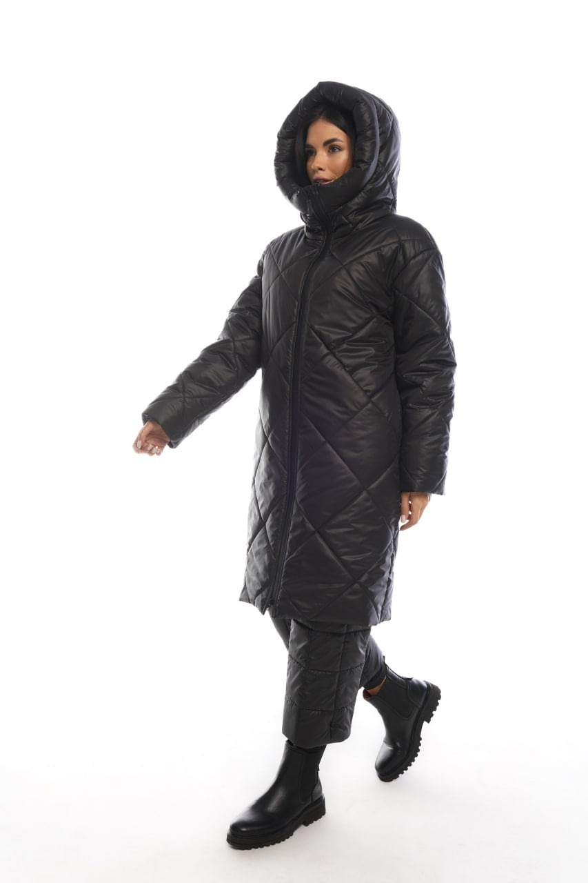 Person wearing a black quilted jacket on a white background