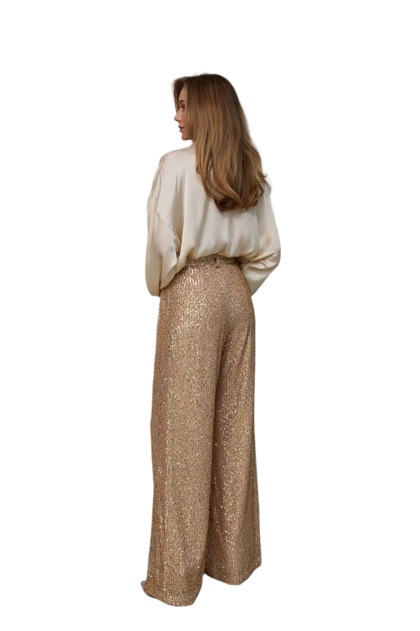 Woman wearing a white top and gold pants on a white background