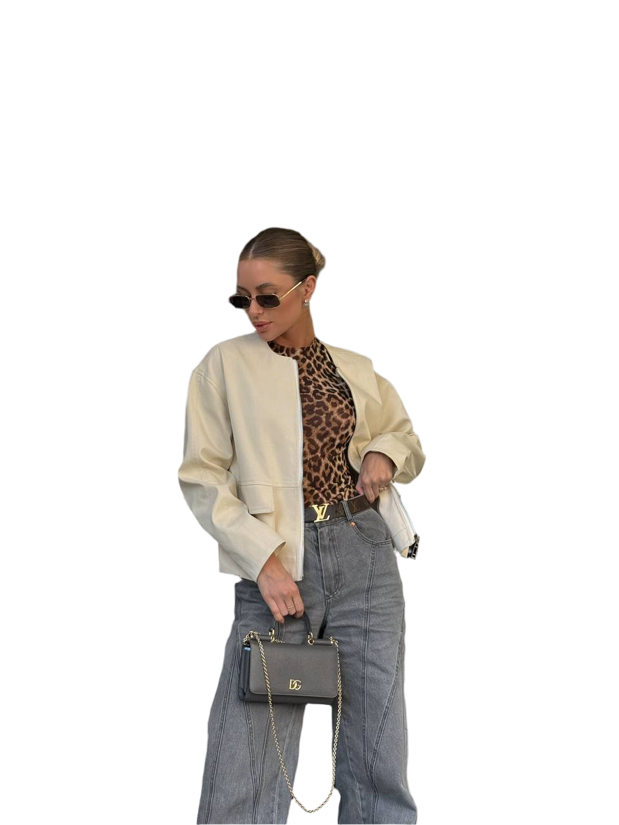 Person wearing a beige cardigan, leopard print top, and gray pants with sunglasses and a handbag on a white background