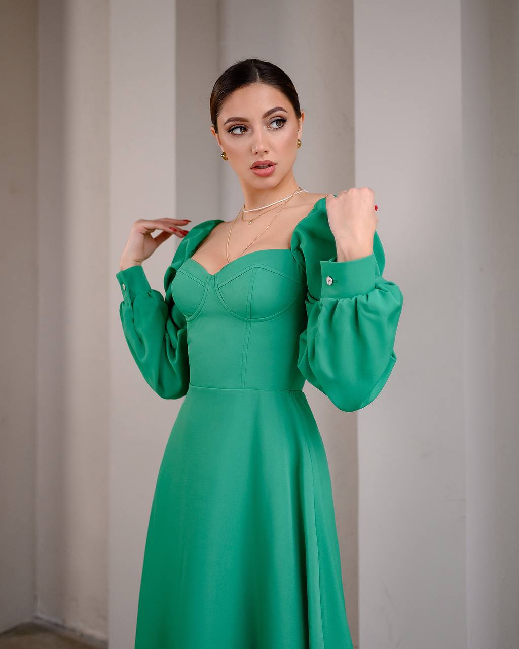 Woman wearing a green dress against a neutral background