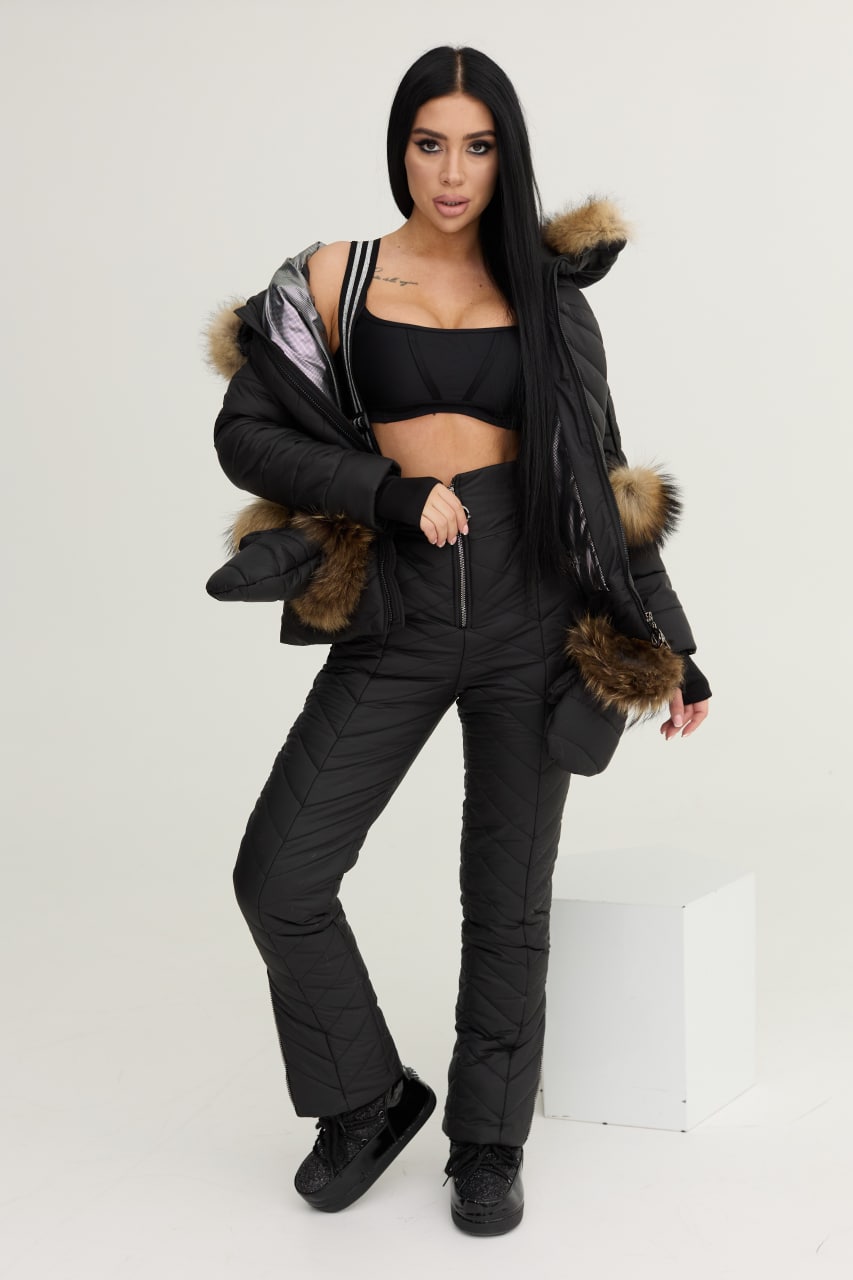 Woman wearing a black winter coat with fur trim on a white background