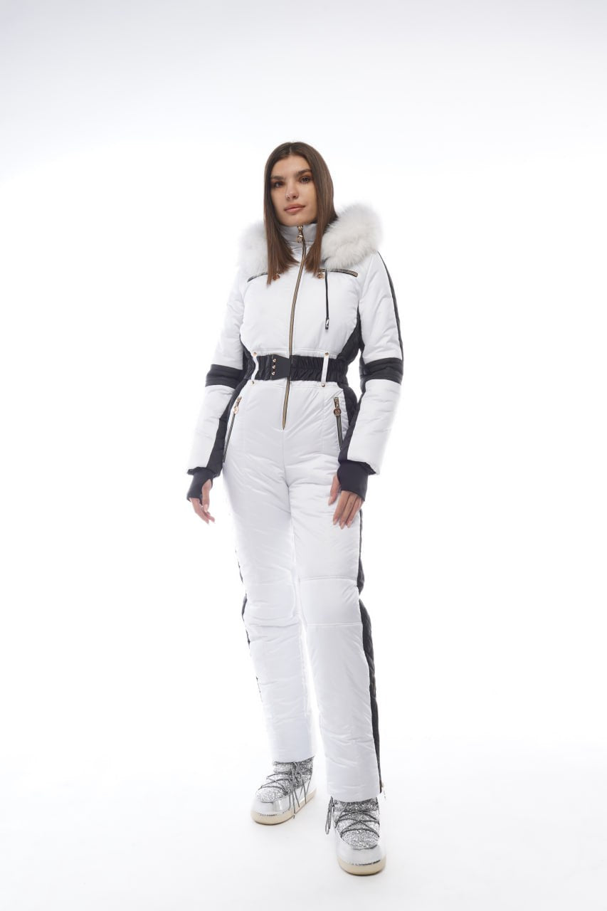 Woman wearing a white ski suit with black accents on a white background