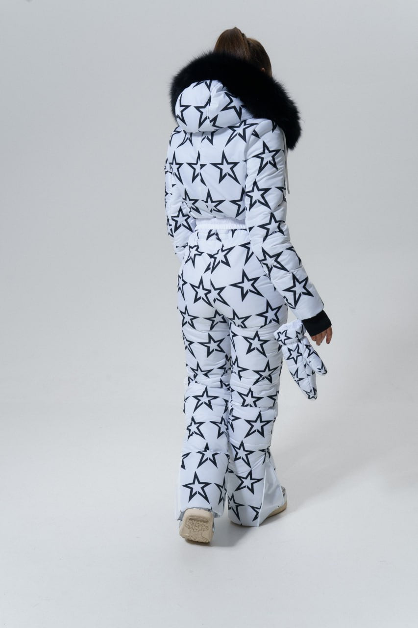 Person wearing a star-patterned outfit with a fur-lined hood on a white background