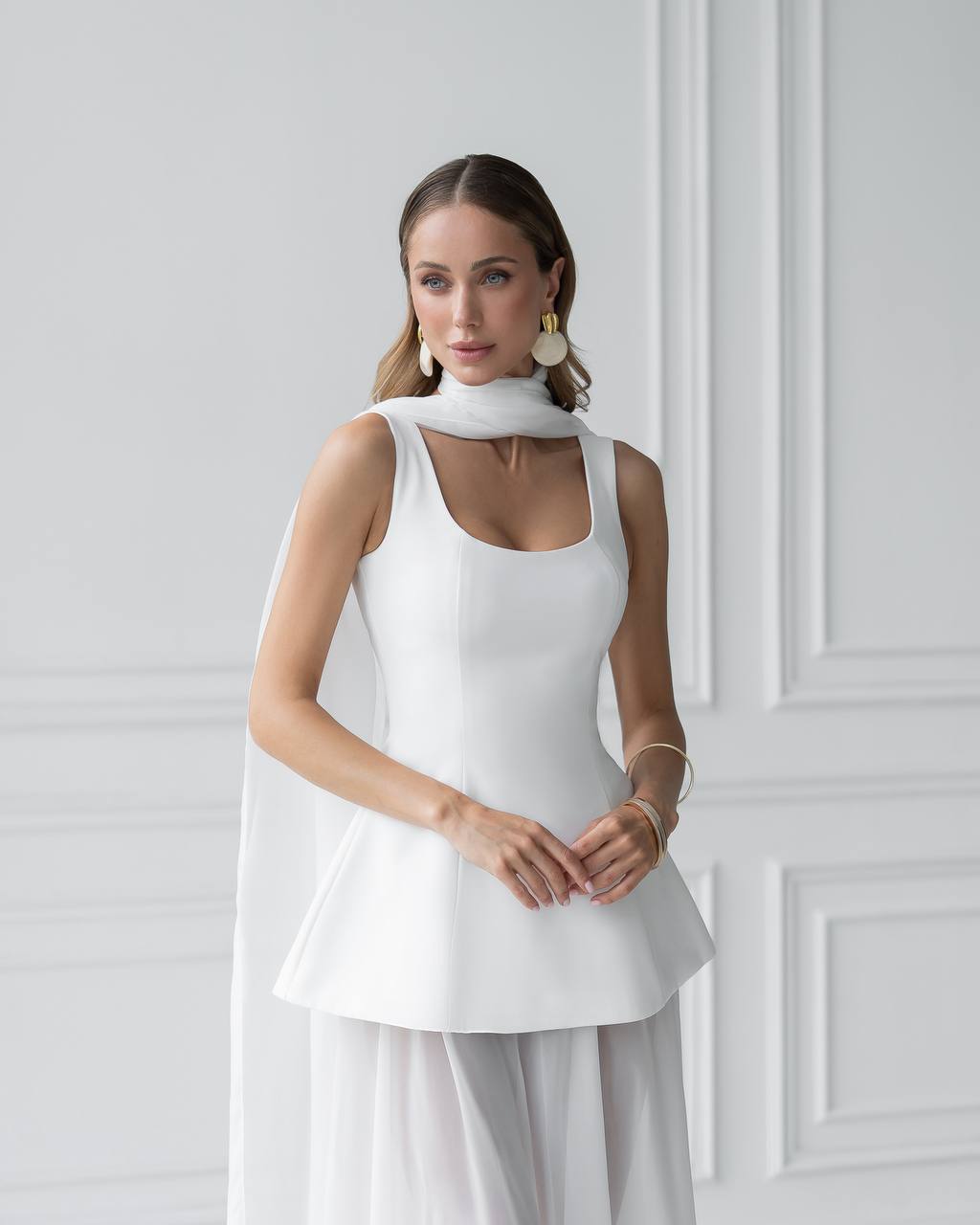 Woman wearing a white dress with a plain background