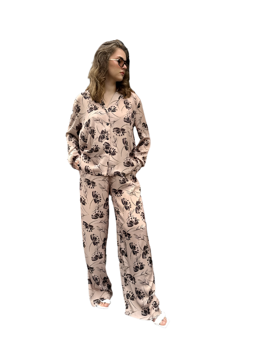 Woman wearing a floral pajama set on a white background