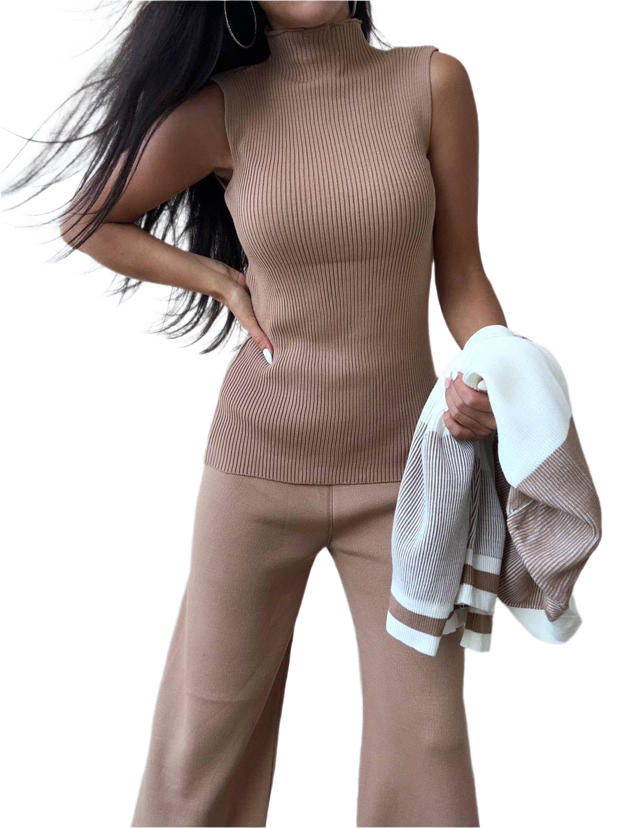 Woman wearing a beige sleeveless top and pants holding a white towel.