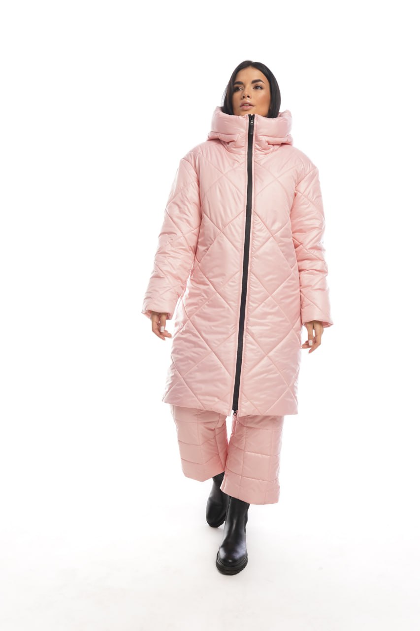 Person wearing a pink quilted coat on a white background
