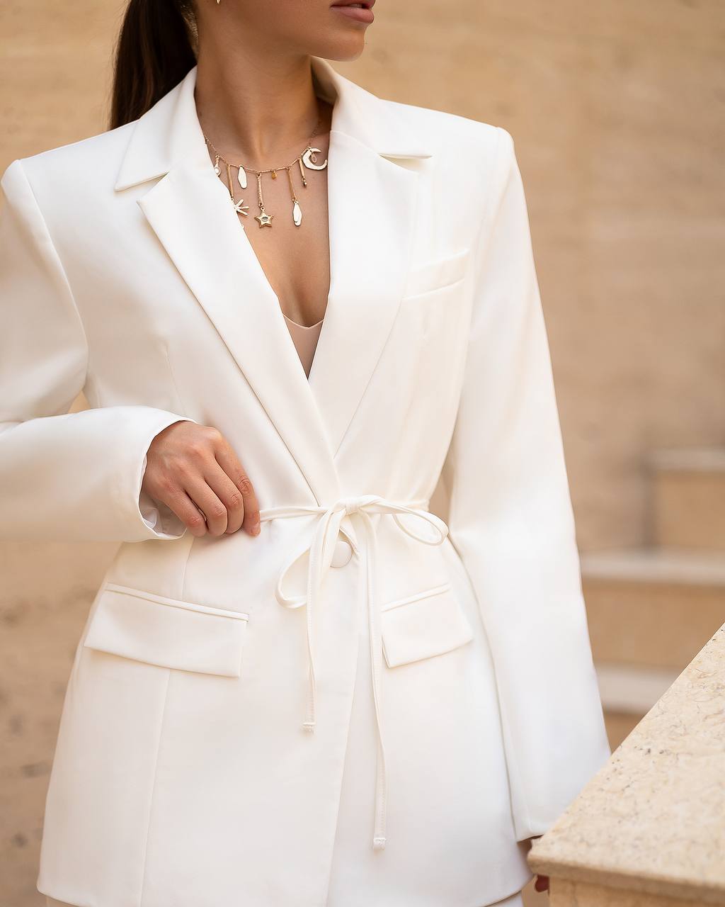 White blazer worn by a person with a blurred background