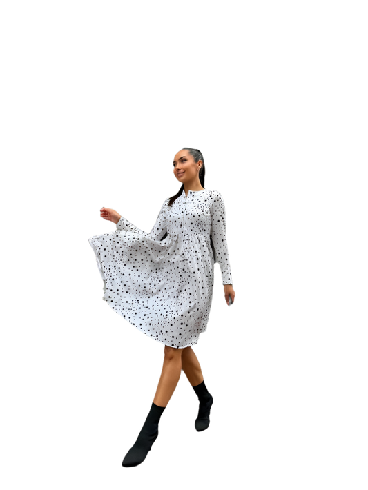 Woman wearing a white dress with black polka dots on a white background