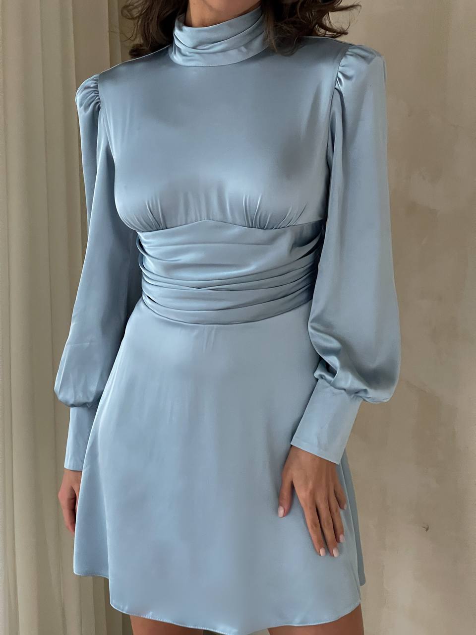Light blue dress with long sleeves on a neutral background