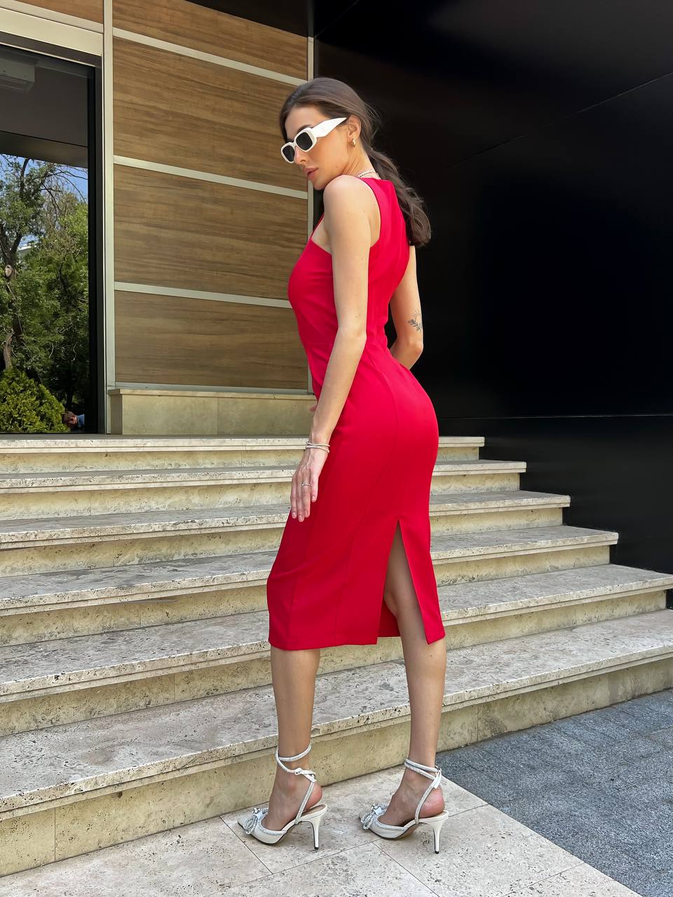 Woman in a red dress standing on steps outdoors