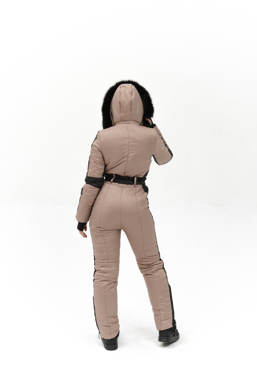 Person wearing a beige snowsuit with black accents on a white background
