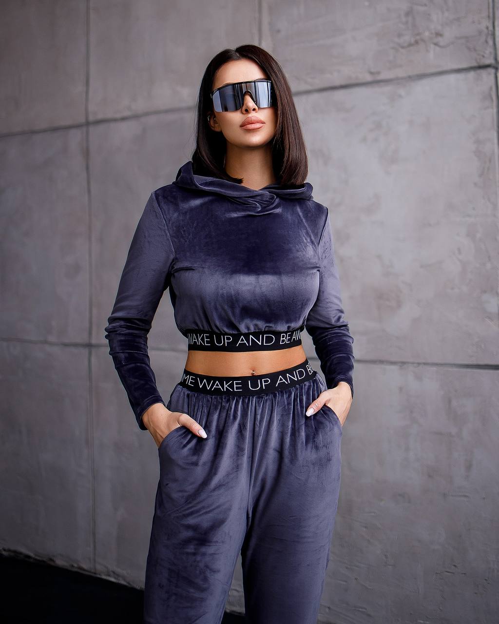 Woman wearing a dark blue athletic outfit with text on a gray background