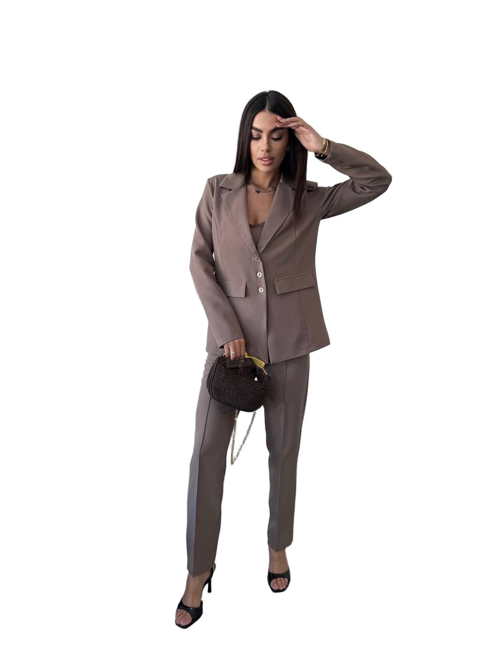 Woman wearing a brown suit holding a handbag on a white background