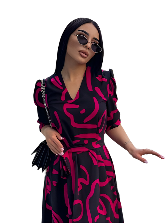 Woman wearing a black and pink patterned dress with sunglasses on a white background