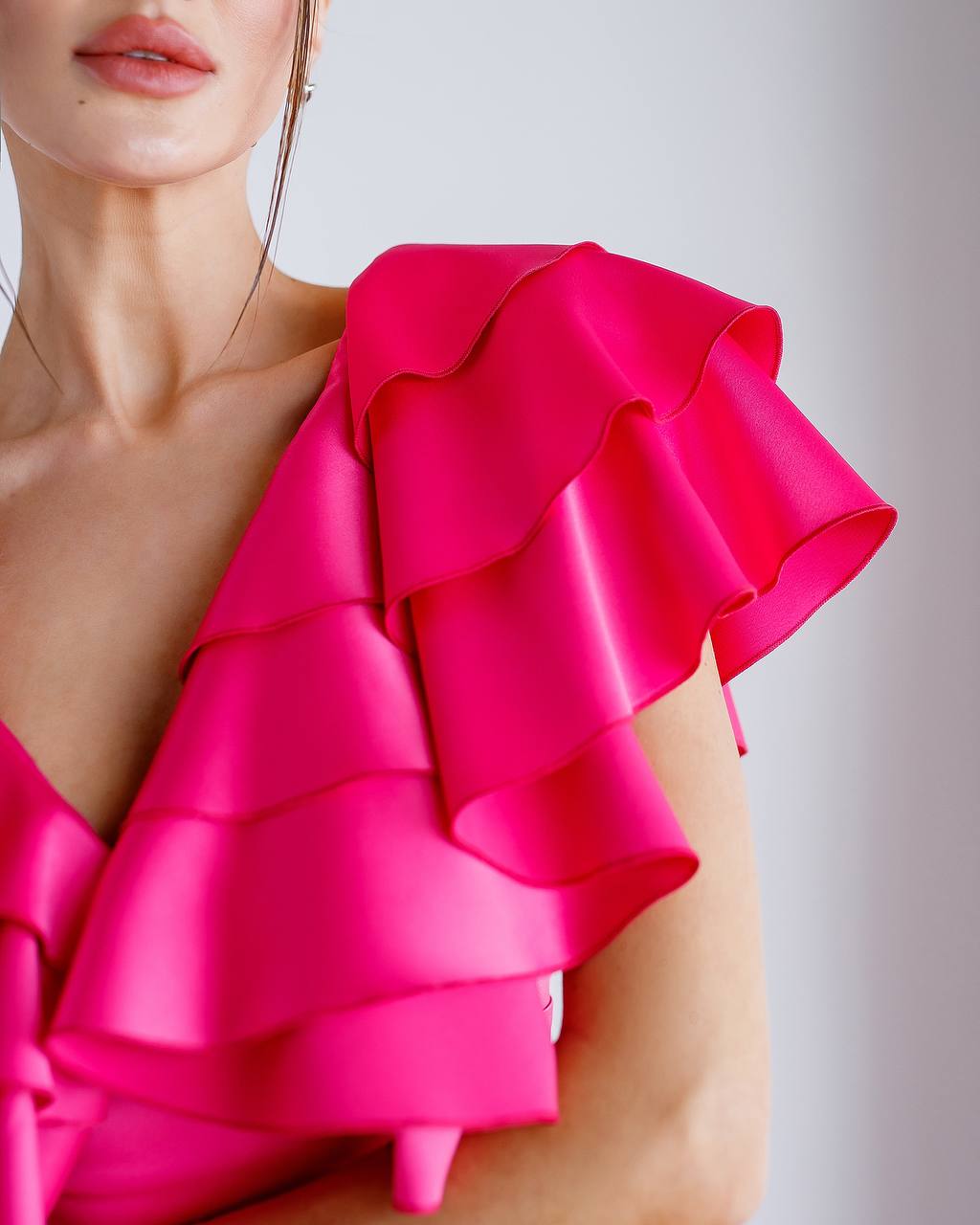 Close-up of a bright pink ruffled top on a blurred background