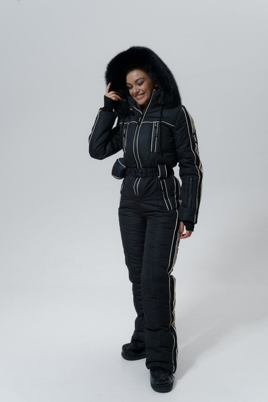Person wearing a black snowsuit with a hood on a white background