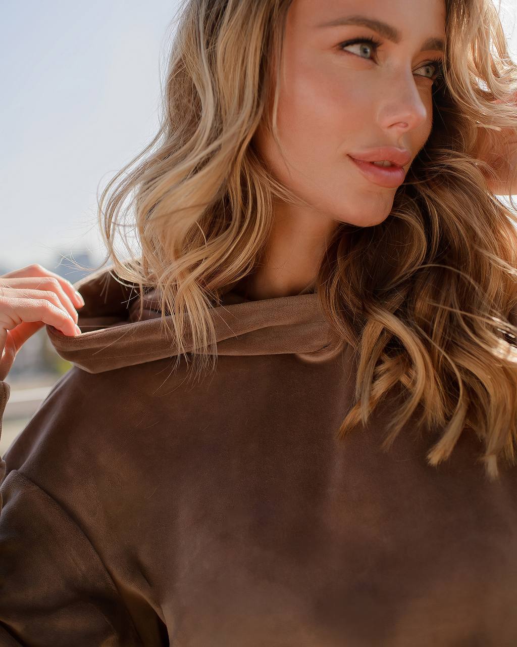 Woman wearing a brown leather jacket with a blurred background