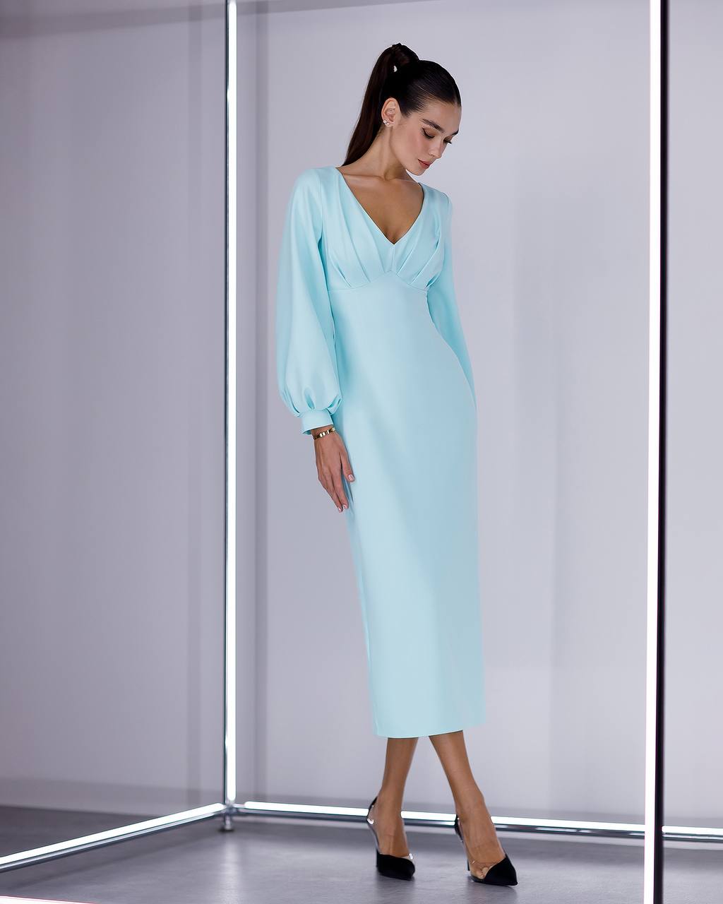 Woman wearing a light blue dress in a minimalistic setting