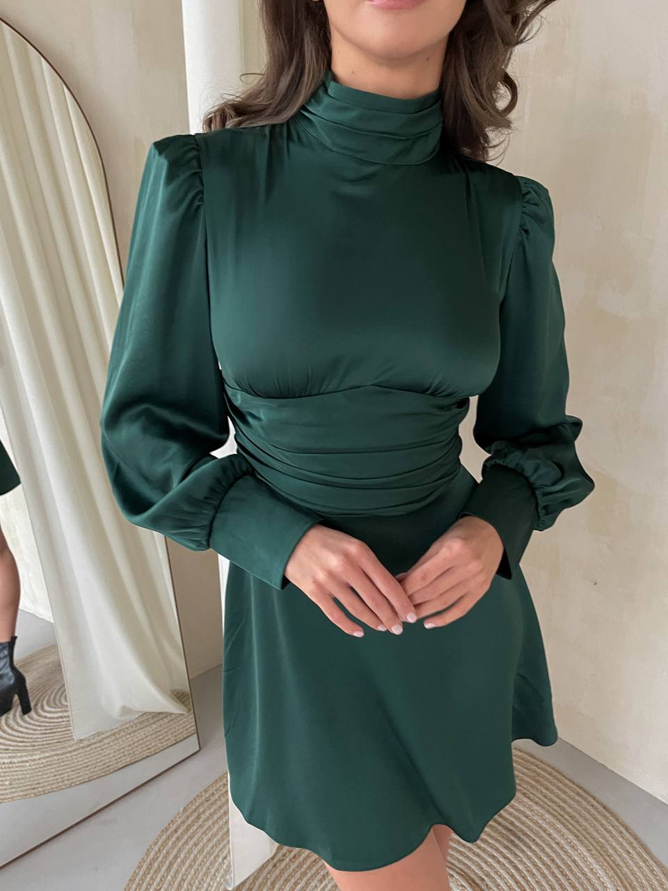Woman wearing a green dress with long sleeves in an indoor setting