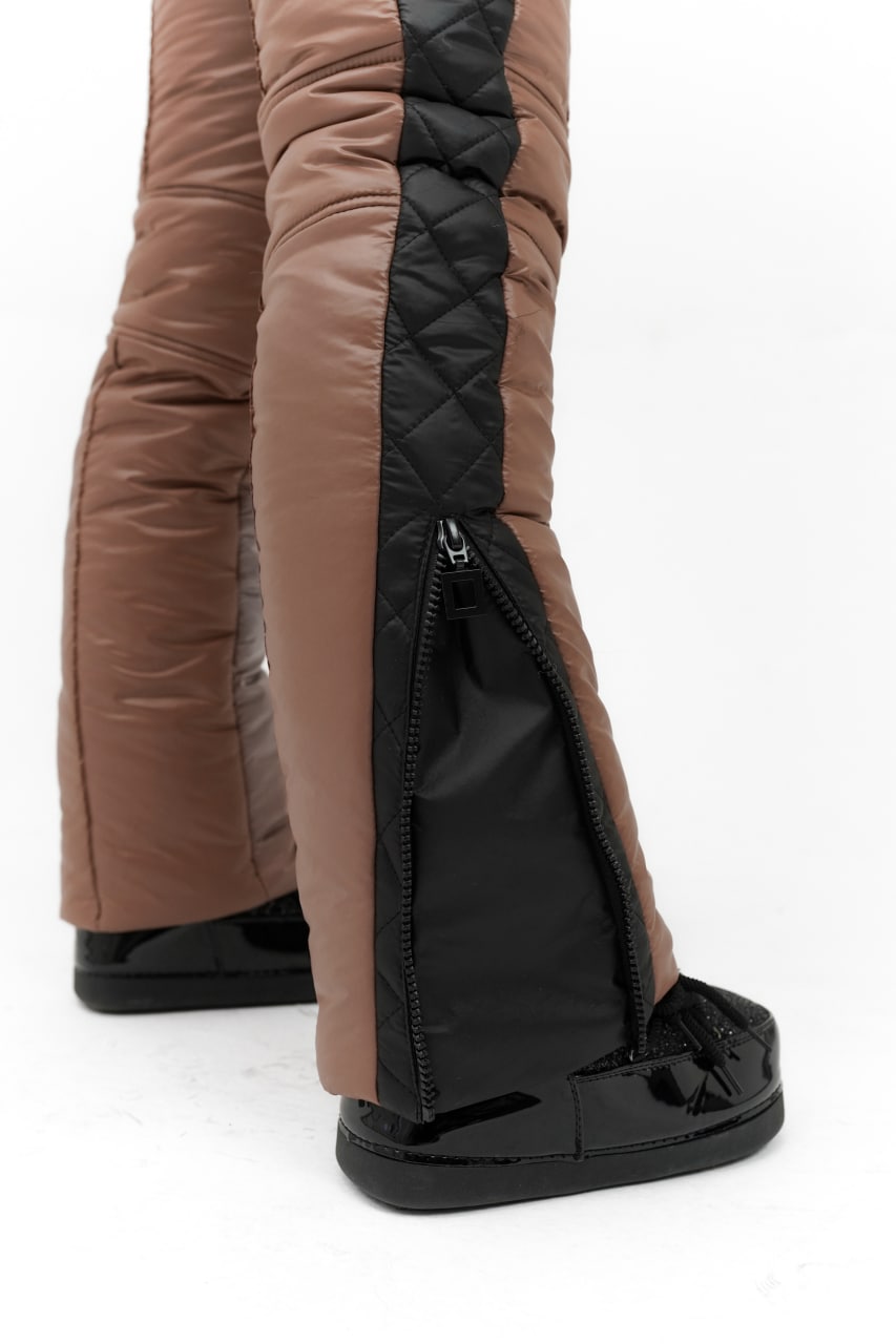 Brown and black riding boots with quilted design on a white background