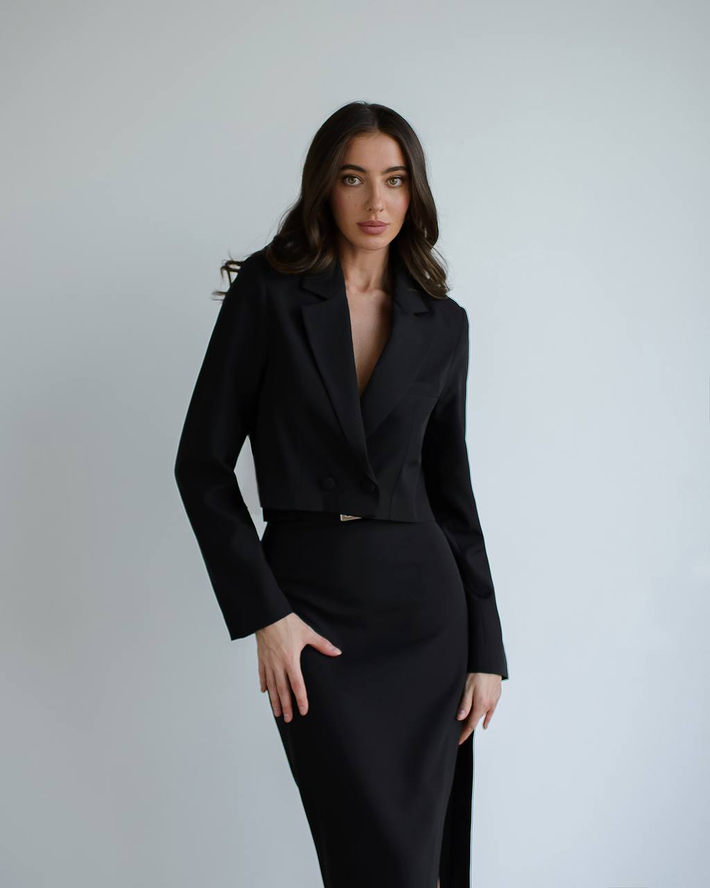 Woman wearing a black suit against a plain background