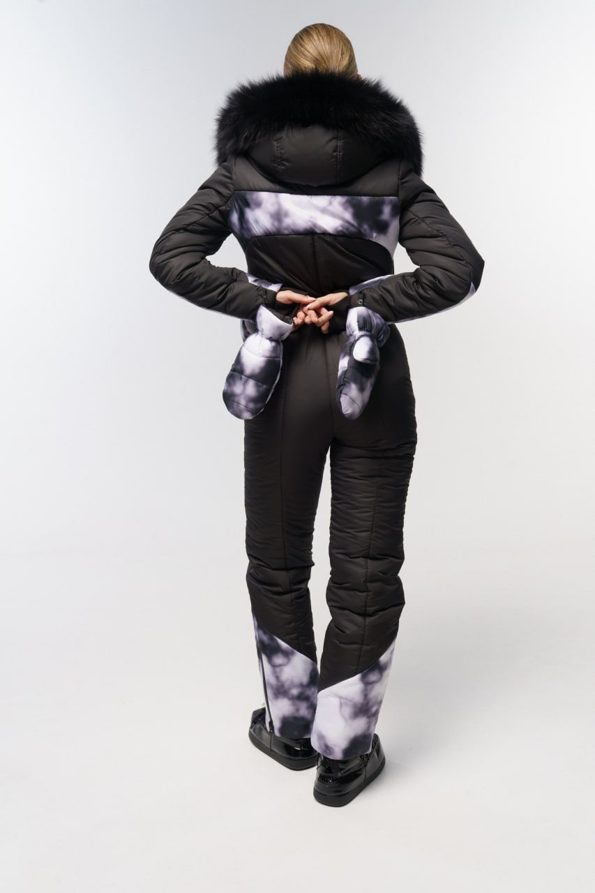Person wearing a black puffer suit with fur hood on a white background