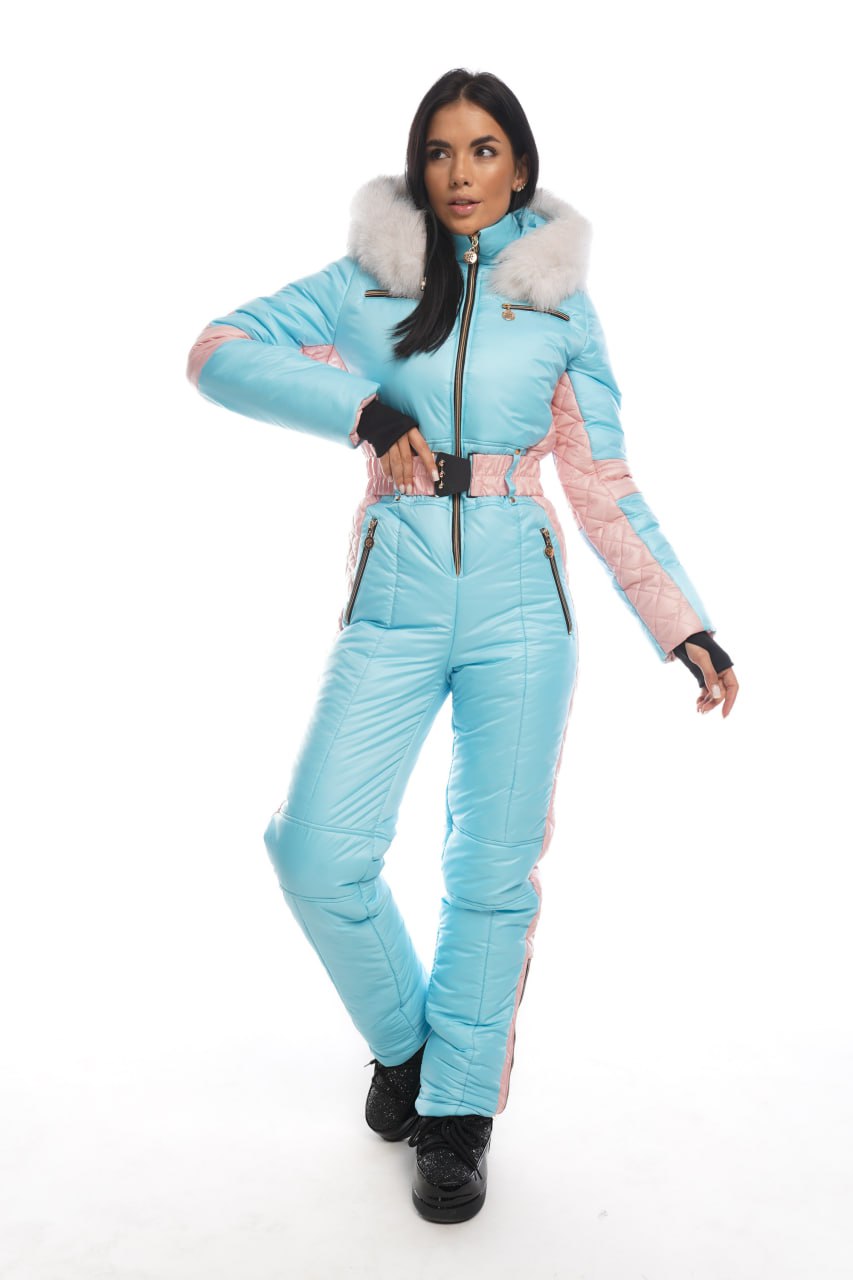 Woman wearing a light blue snowsuit with pink accents on a white background
