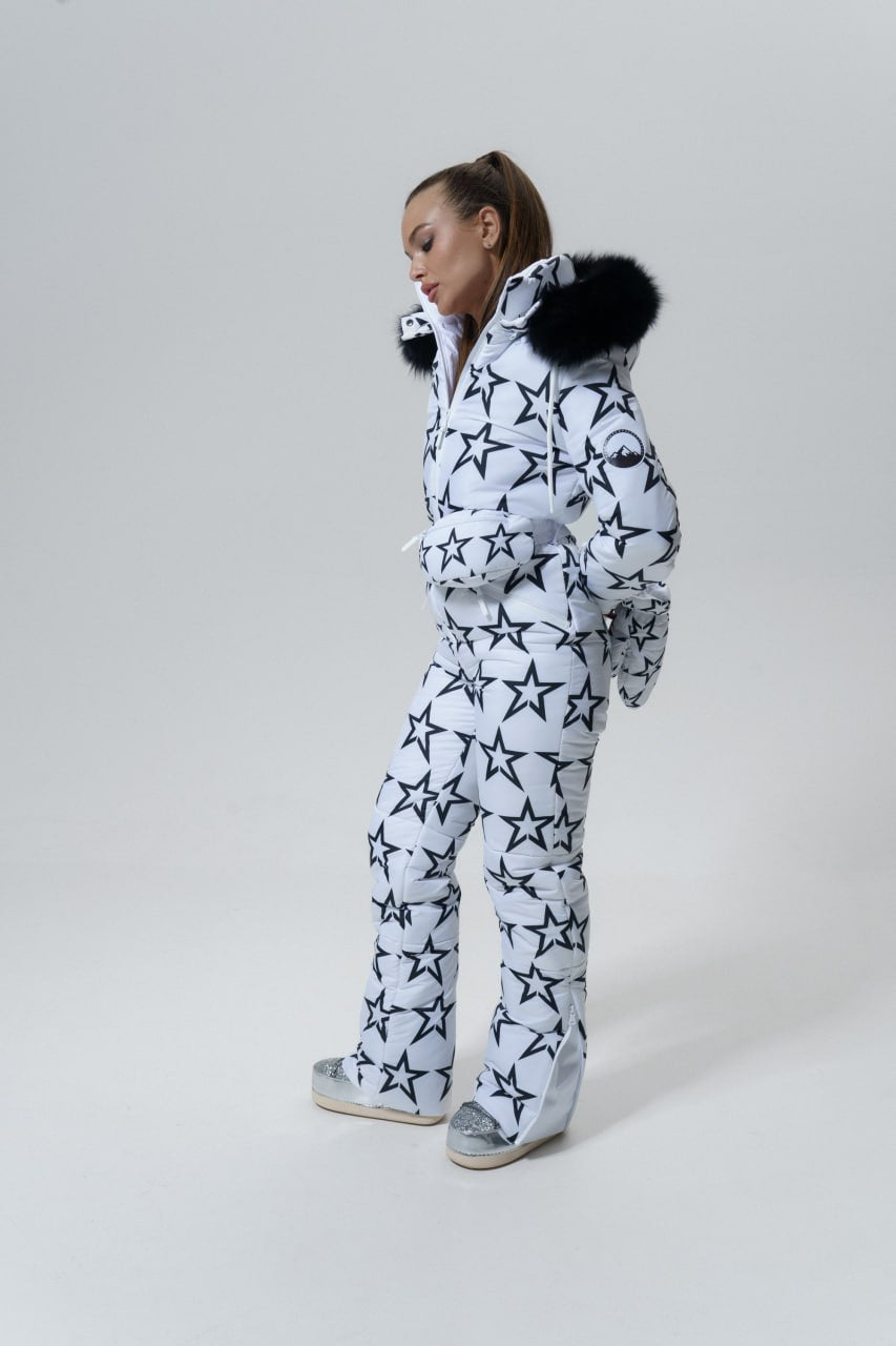Person wearing a star-patterned snowsuit with fur hood on a white background