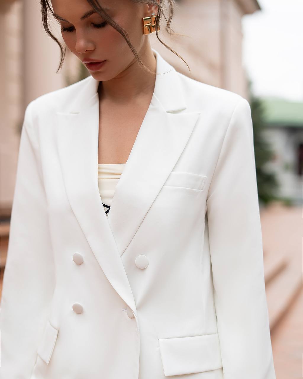 Woman wearing a white blazer with a blurred background
