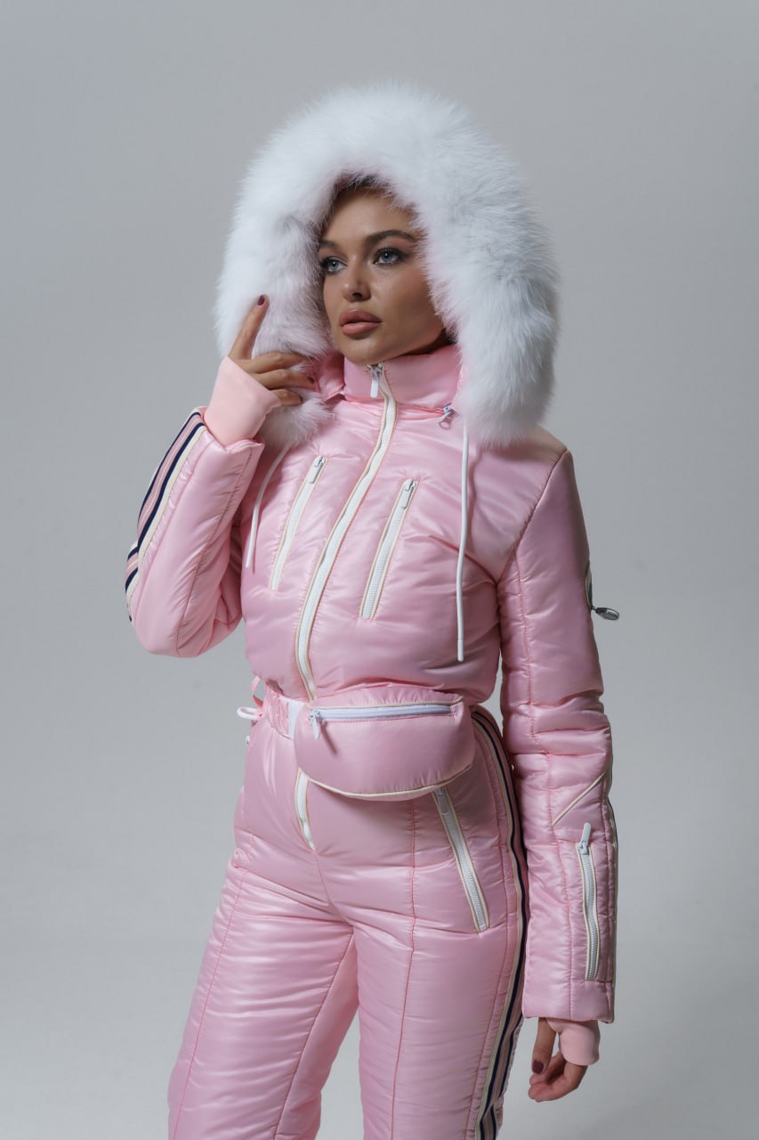 Person wearing a pink winter outfit with a fur-lined hood on a gray background
