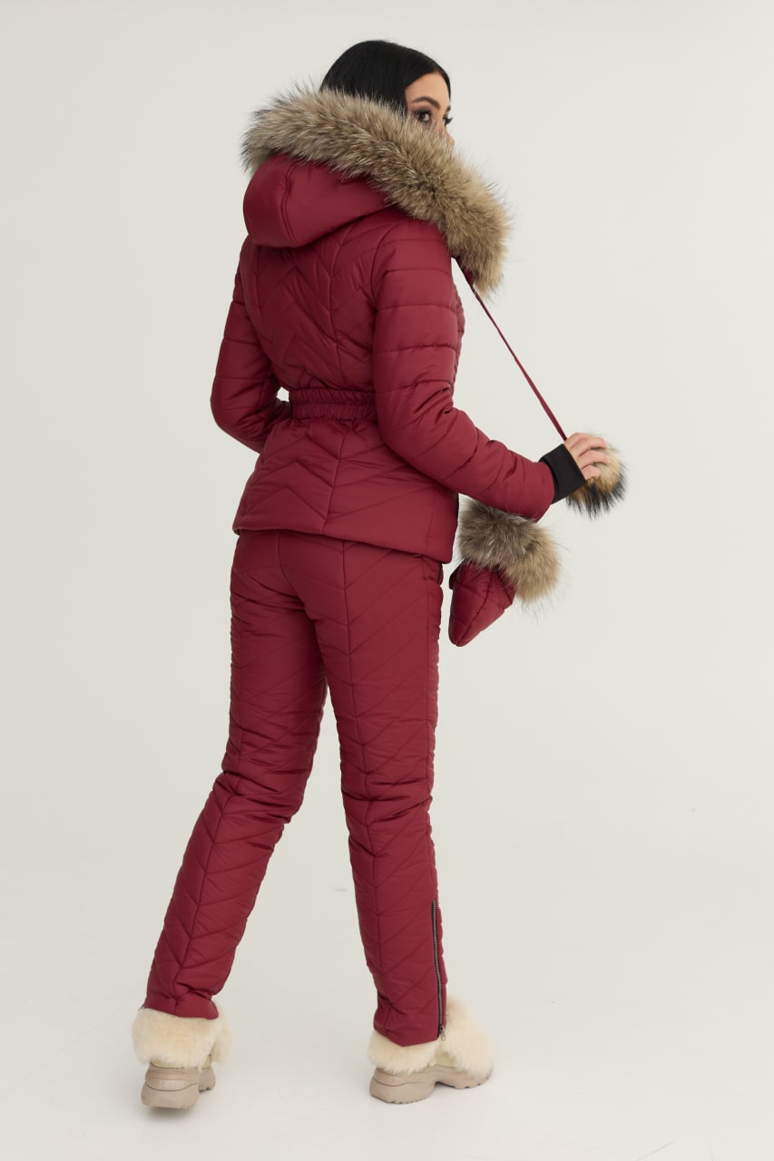 Person wearing a red winter outfit with fur-lined hood and cuffs on a white background