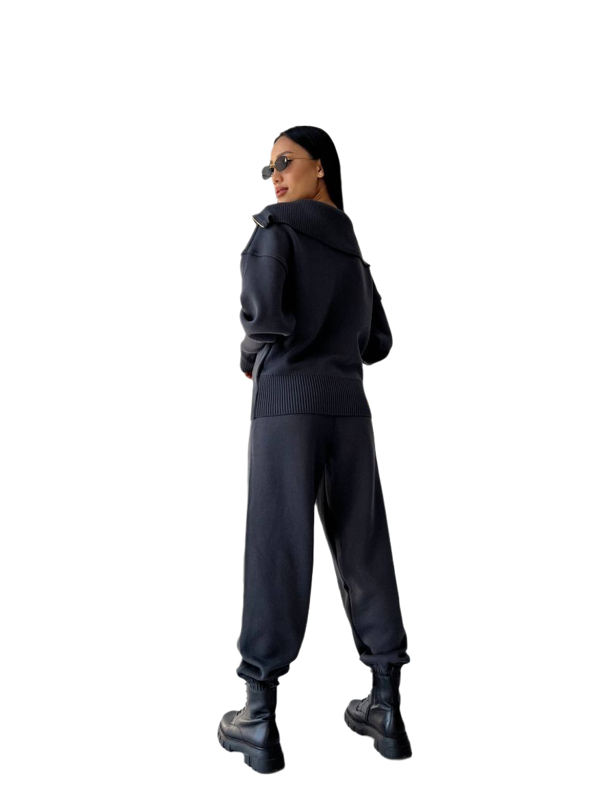 Person wearing a black hoodie and pants on a white background