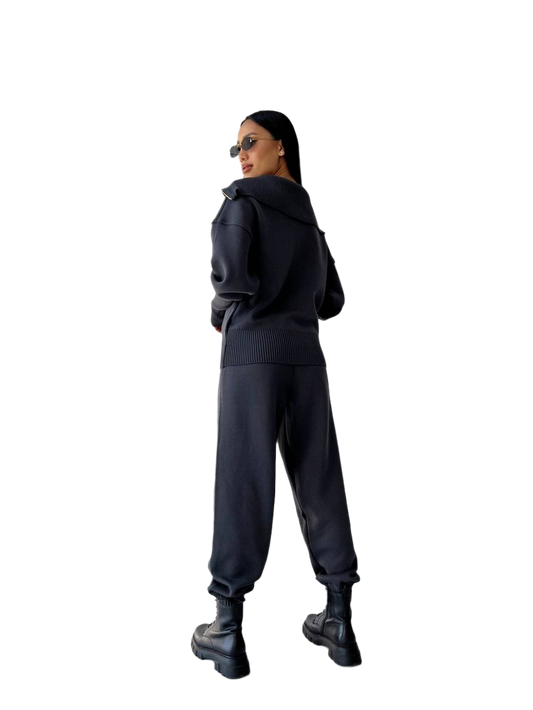 Person wearing a black hoodie and pants on a white background