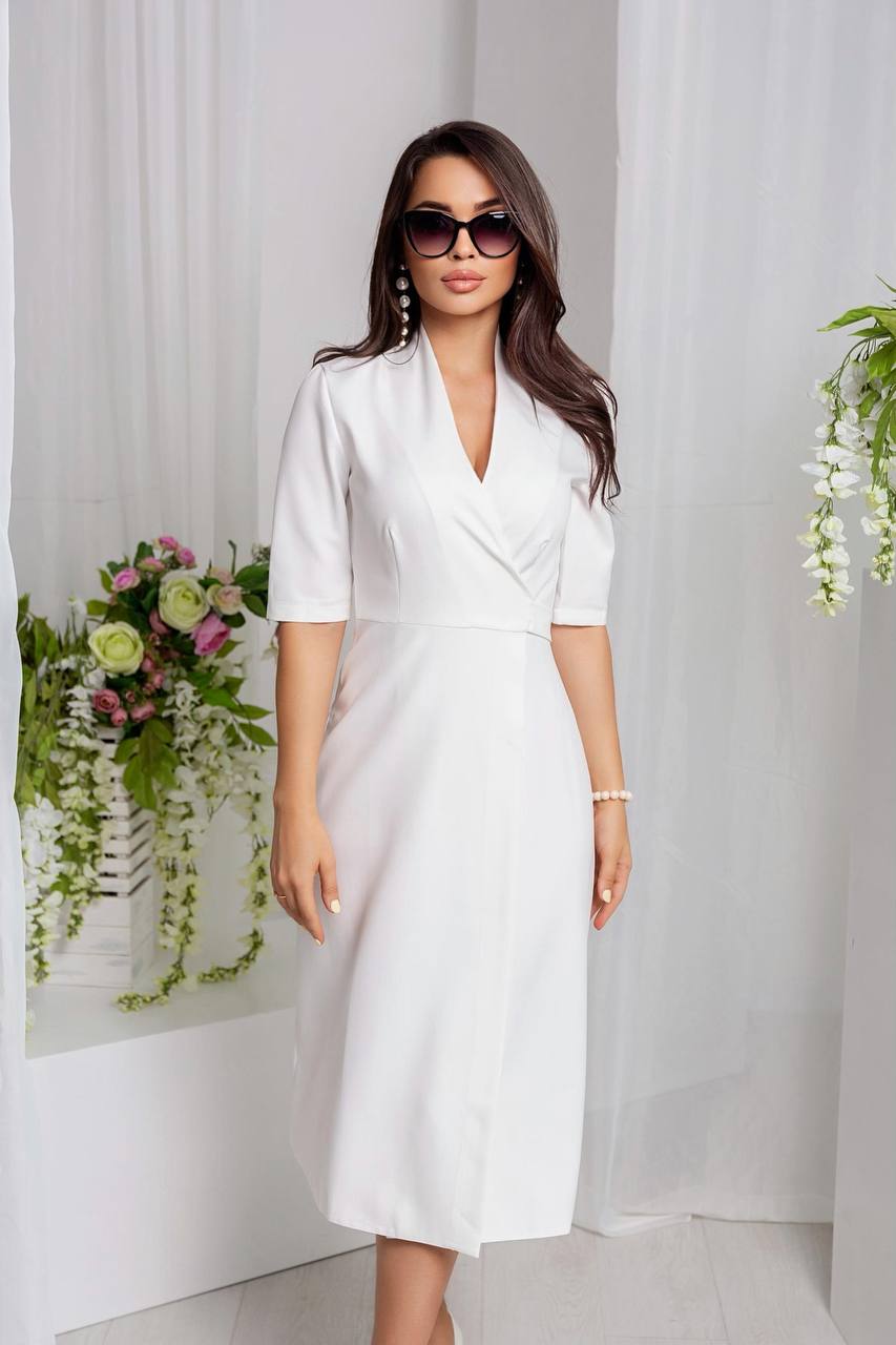 Woman wearing a white dress with floral decorations in the background