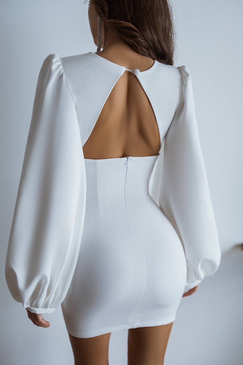 White dress with cut-out back design on a plain background