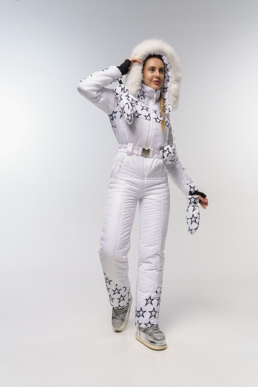 Person wearing a white snowsuit with star patterns on a plain background