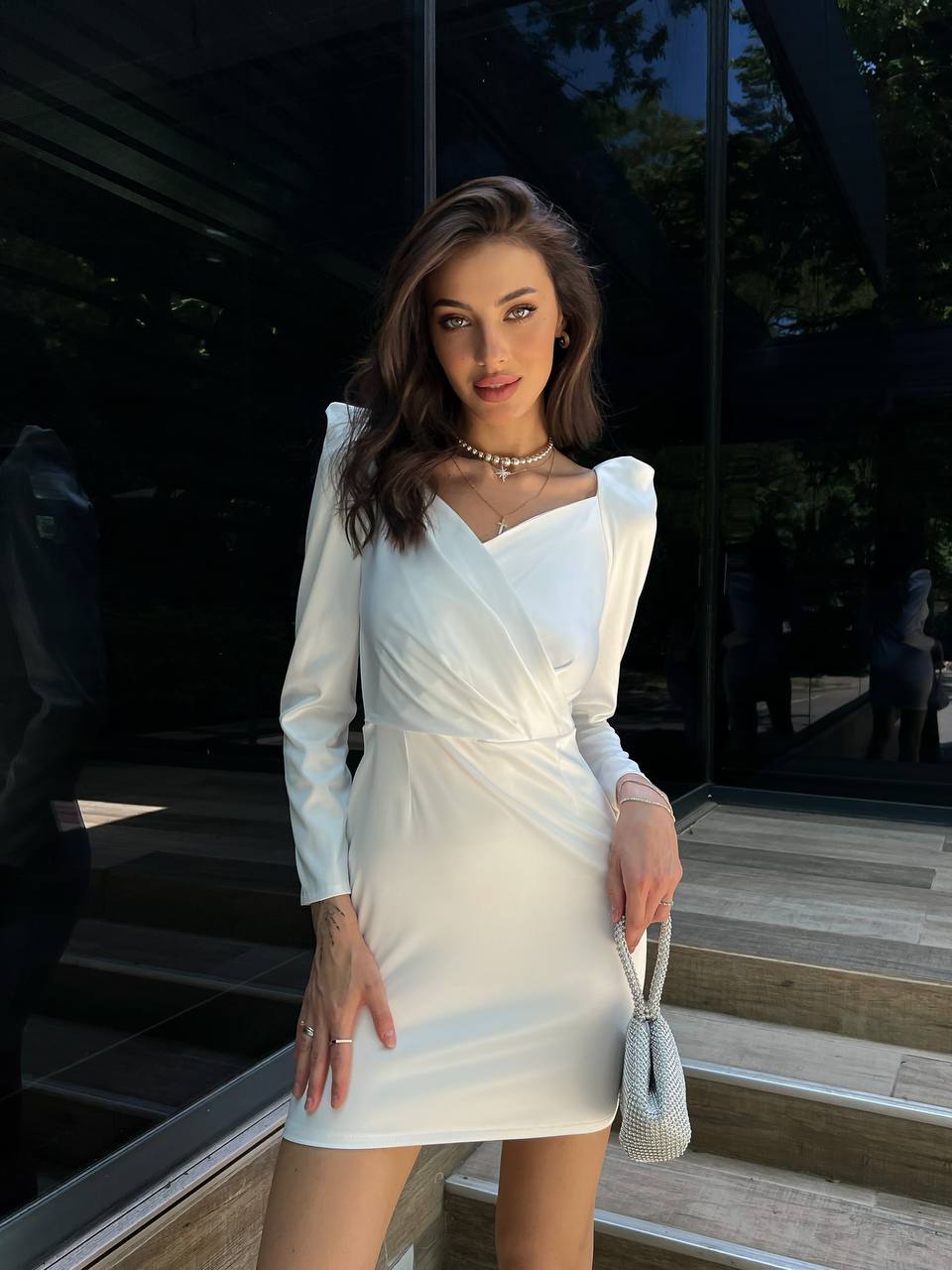 Woman in a white dress standing outdoors on steps