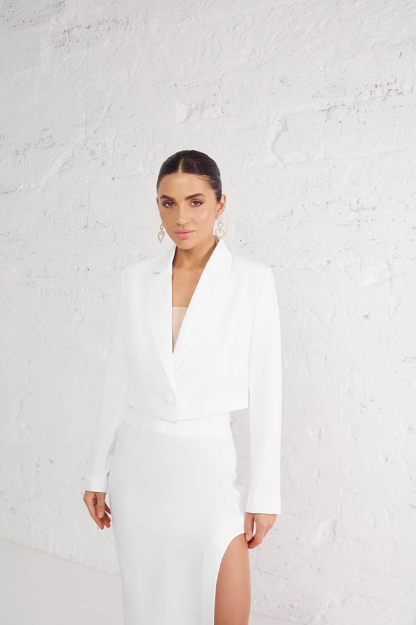 Woman wearing a white dress with a textured white background