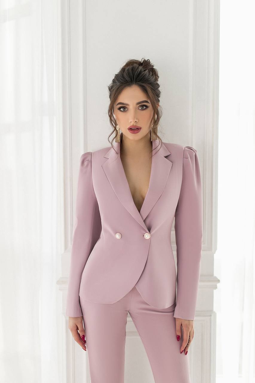 Woman wearing a pink suit against a white background