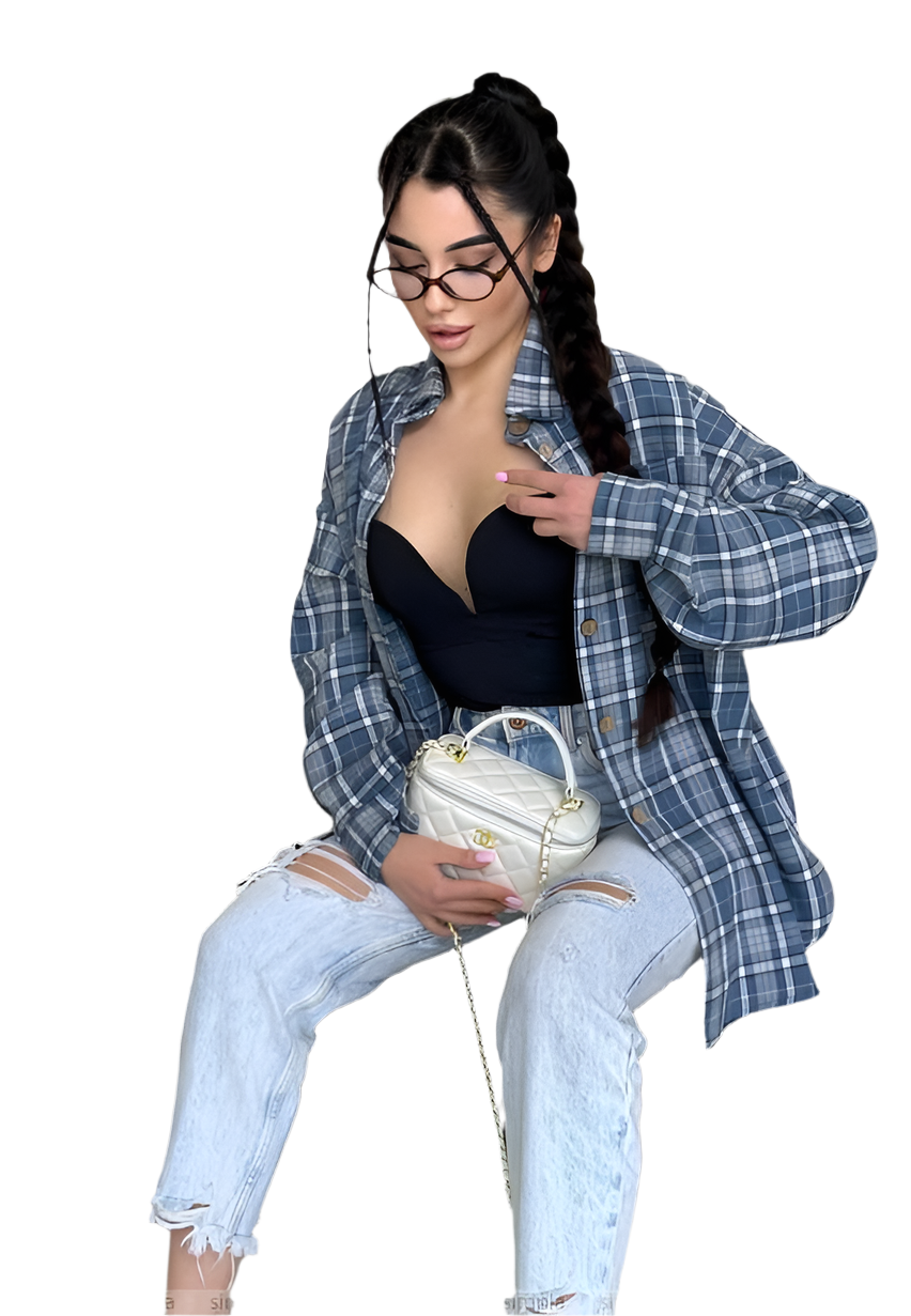 Woman wearing a blue plaid shirt over a black top and light blue jeans, sitting on a white background.