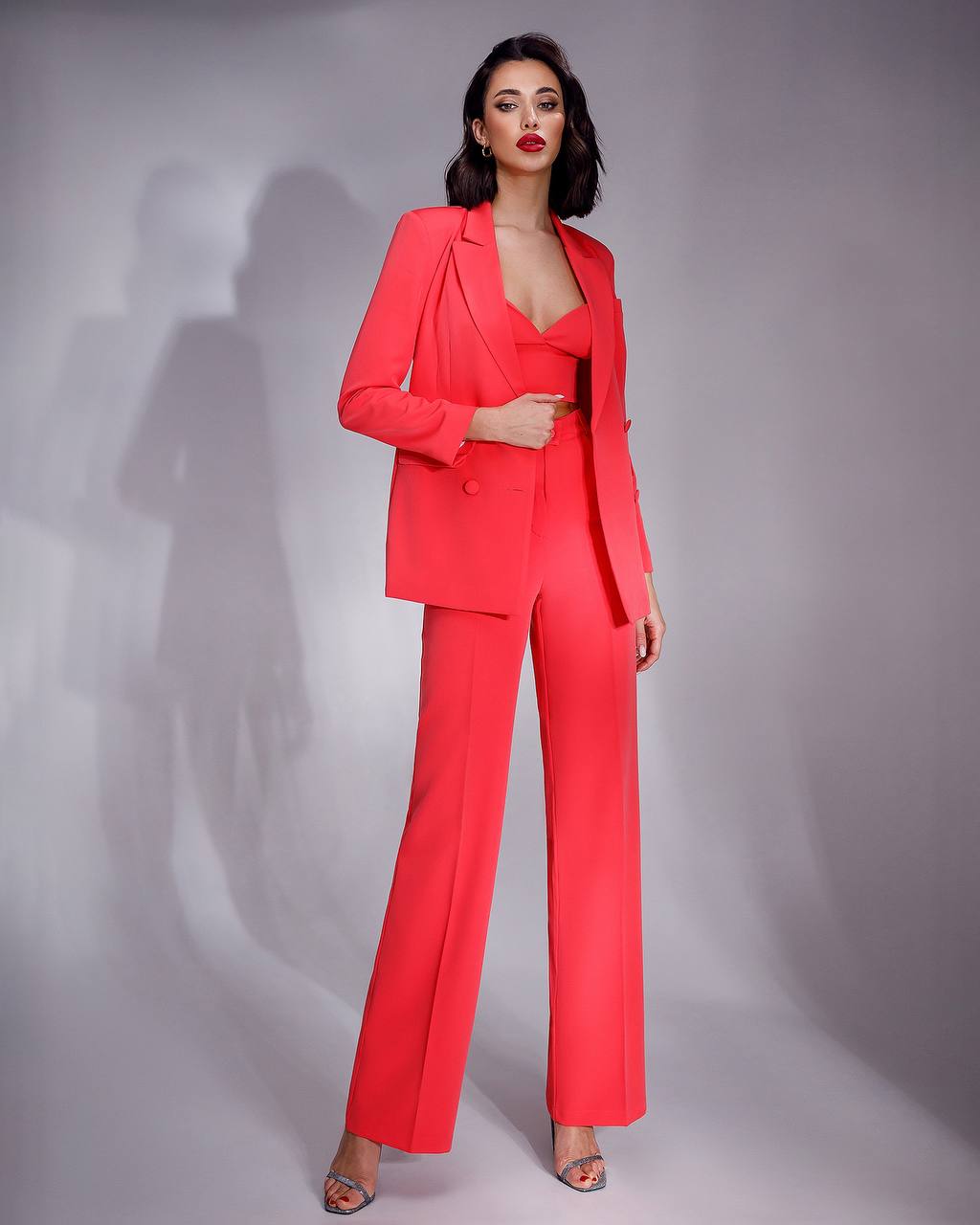 Woman wearing a red suit against a gray background