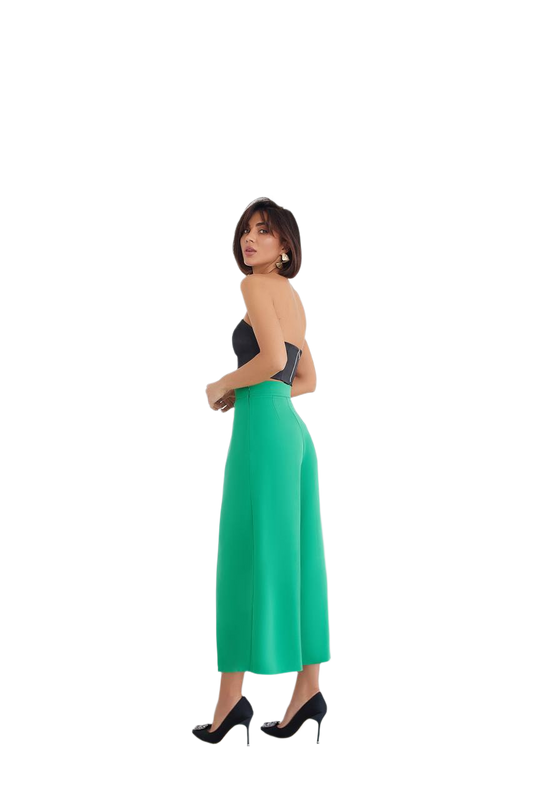 Woman wearing a strapless top and green skirt on a white background