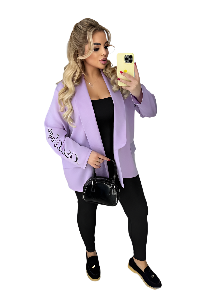 Woman wearing a light purple jacket with text, taking a selfie on a white background