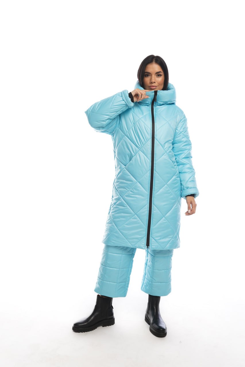 Person wearing a light blue puffer coat and pants on a white background