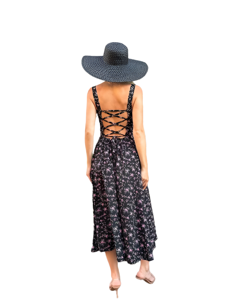 Woman wearing a black floral dress with lace-up back and a wide-brimmed hat on a white background