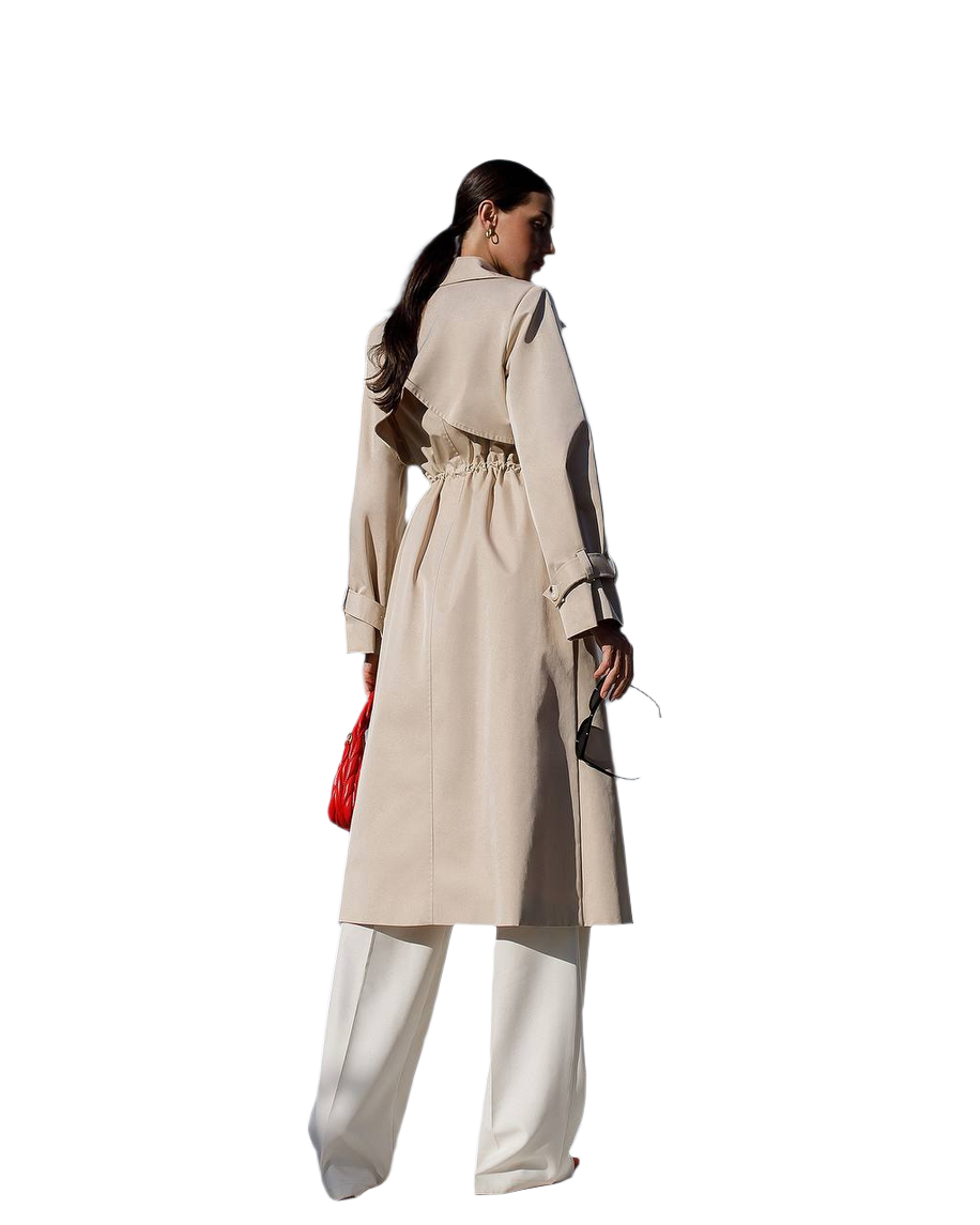 Woman wearing a beige trench coat with a red bag on a white background